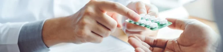 Doctor hands patient a packet of medication