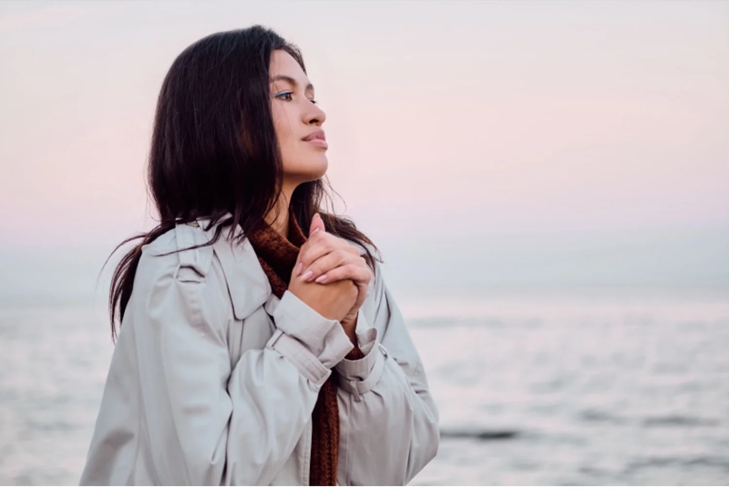 Young woman looks wistful during a sunset walk on the beach