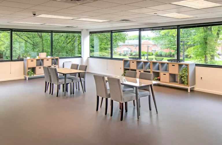 Activity room with tables, cubbies, and views out to a green lawn at Legacy Healing Center’s Parsippany drug and alcohol rehab